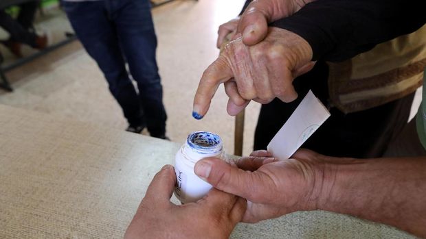 Warga Palestina mencelupkan jari ke dalam tinta usai menggunakan hak suaranya di Tepi Barat