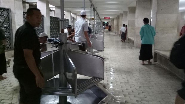 Jemaah pria mengambil wudu