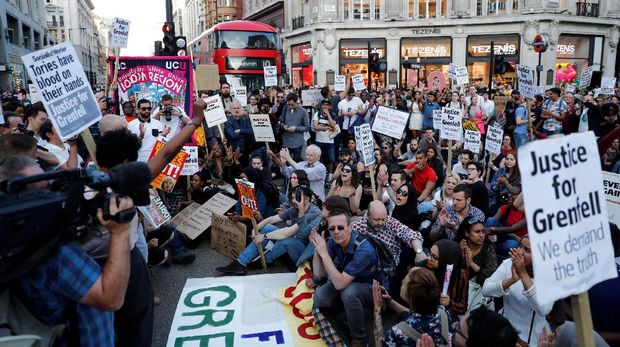 Demonstran memprotes pengelola apartemen London yang terbakar hebat