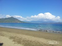 Suasana pemandangan pantai Poto Balat dimana pantainya di kelilingi pegunungan yang hijau dan pasir cokelat terhampar seperti permadani Suasana pemandangan pantai Poto Balat dimana pantainya di kelilingi pegunungan yang hijau dan pasir cokelat terhampar seperti permadani